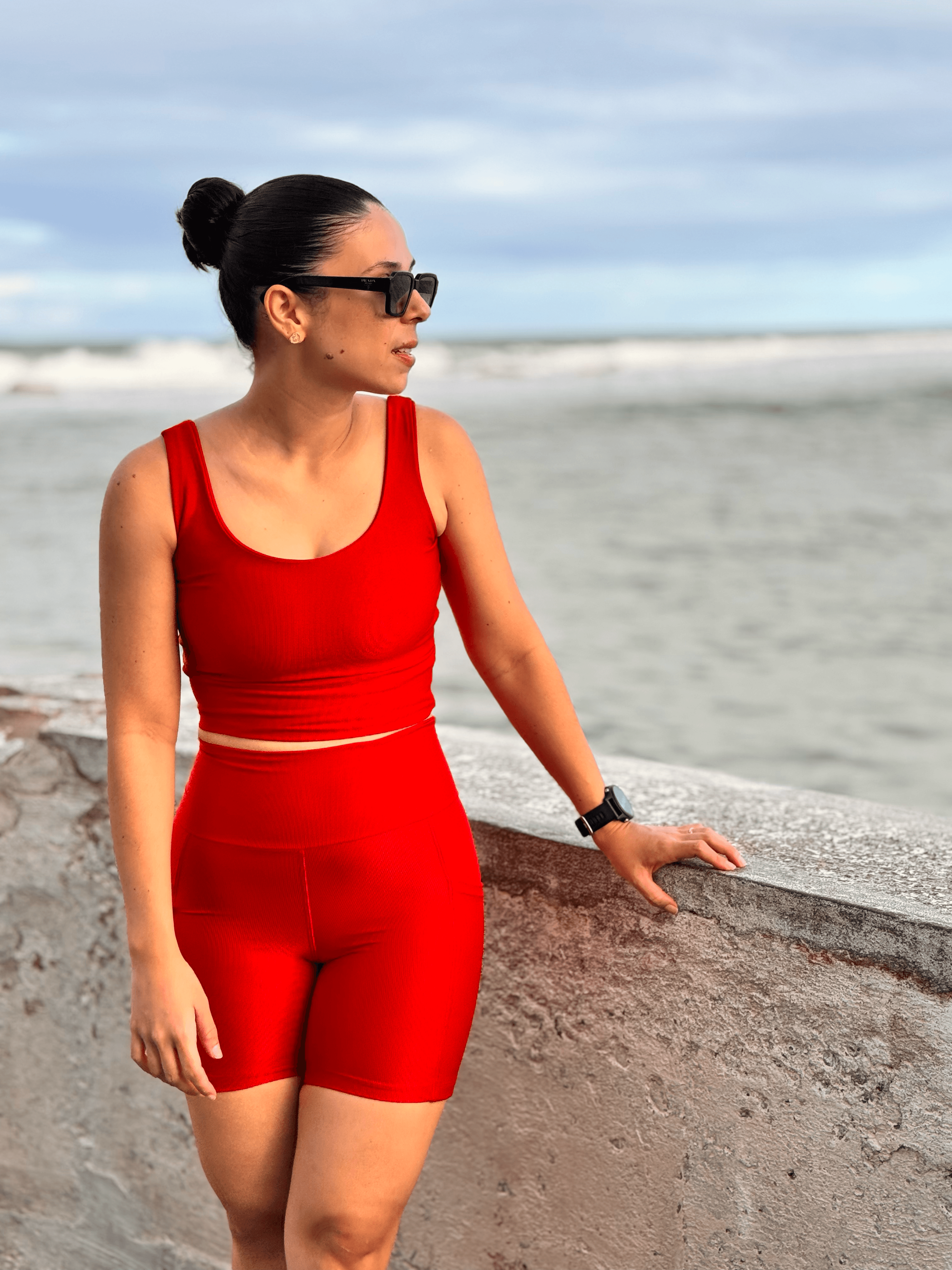 Modelo Nola Fitness usando conjunto vermelho à beira-mar
