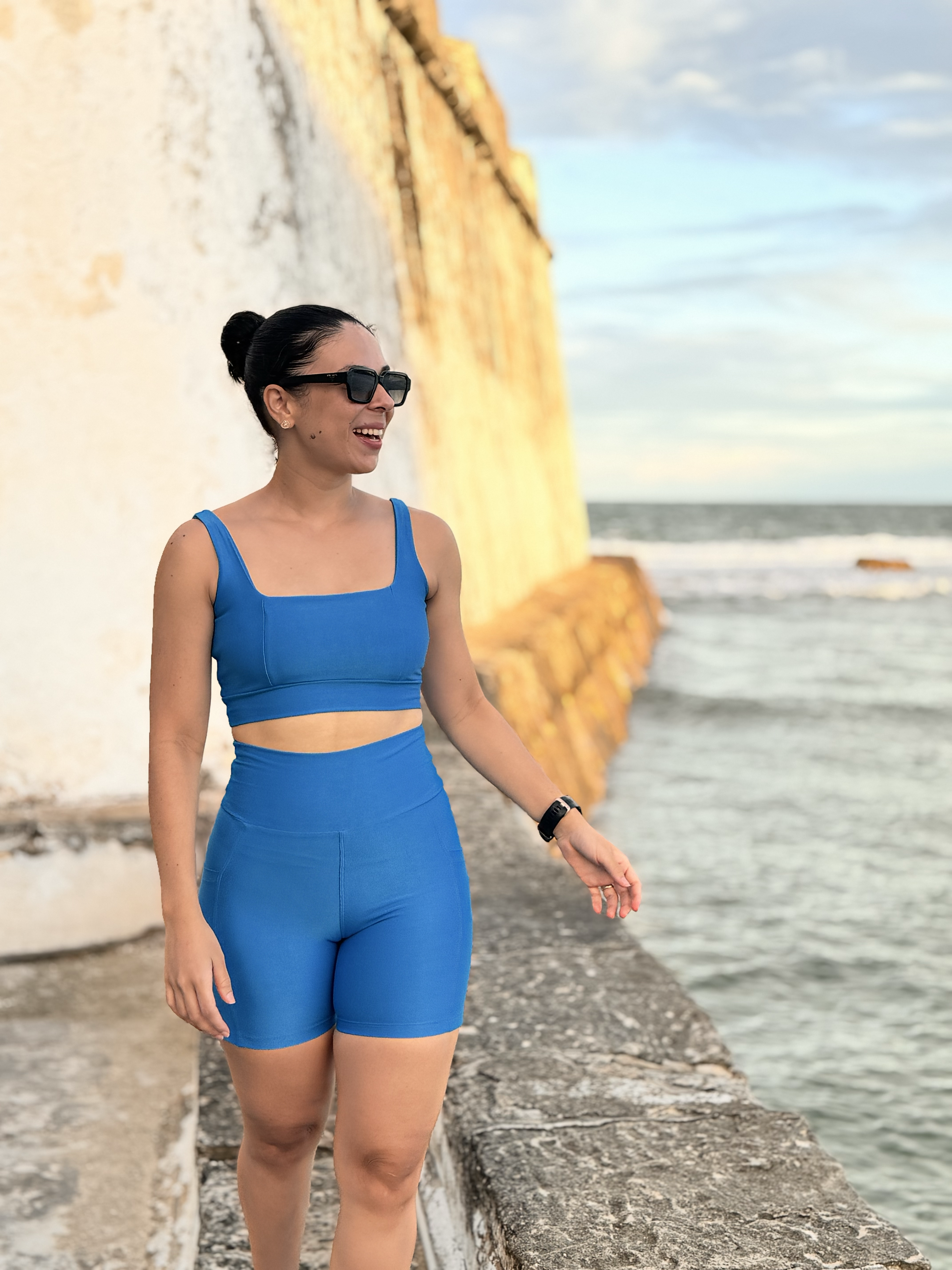 Modelo Nola Fitness usando o conjunto Pulse azul à beira-mar